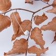 Load image into Gallery viewer, Silver cube necklace, reflecting light as it dangles from a autumnal branch of orange-brown leaves