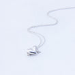 Load image into Gallery viewer, Close up view of carved silver heart necklace, chain in wave behind