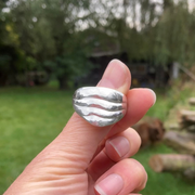 Solid silver ripple ring commission, cast from wax with garden and trees behind