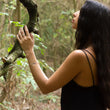 Load image into Gallery viewer, Handmade silver bracelet on woman's arm, with a ring on her hand, which holds a tree branch as she looks up