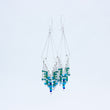 Load image into Gallery viewer, Windcharm earrings, one straight on and the other at an angle so the silver chain threaded through tube can be seen
