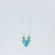 Load image into Gallery viewer, Slightly sideways view of Windcharm necklace on white background showing how chain threads through tube on top of pendant, and the colourful beads below