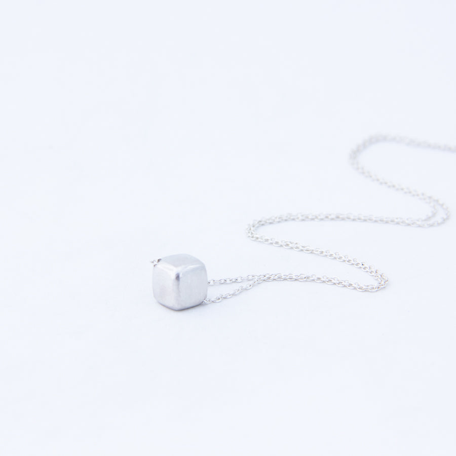 Silver cube necklace - the cube with blunted edges, with chain in a ripple behind