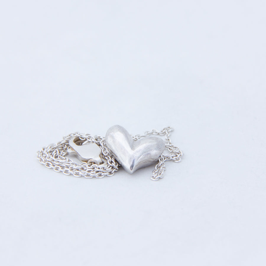 Delicate silver heart with chain and lobster clasp gathered  close to it's side