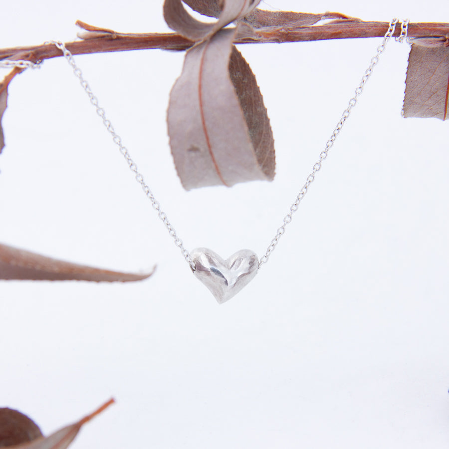 Delicate silver heart with chain and lobster clasp gathered  close to it's side