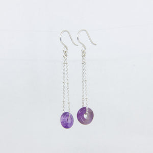 Silver dangle earrings with purple gemstones on a white background