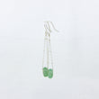 Load image into Gallery viewer, Silver dangle earrings with green gemstones on a white background
