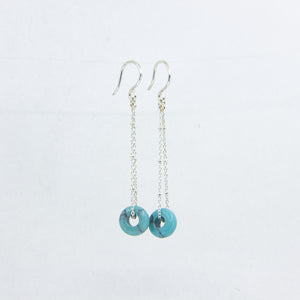 Turquoise gemstone and silver chain earrings on white background