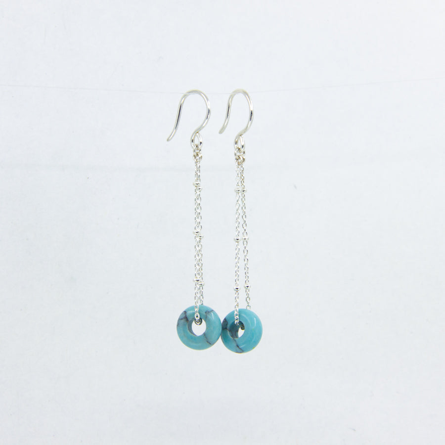 Turquoise gemstone and silver chain earrings on white background