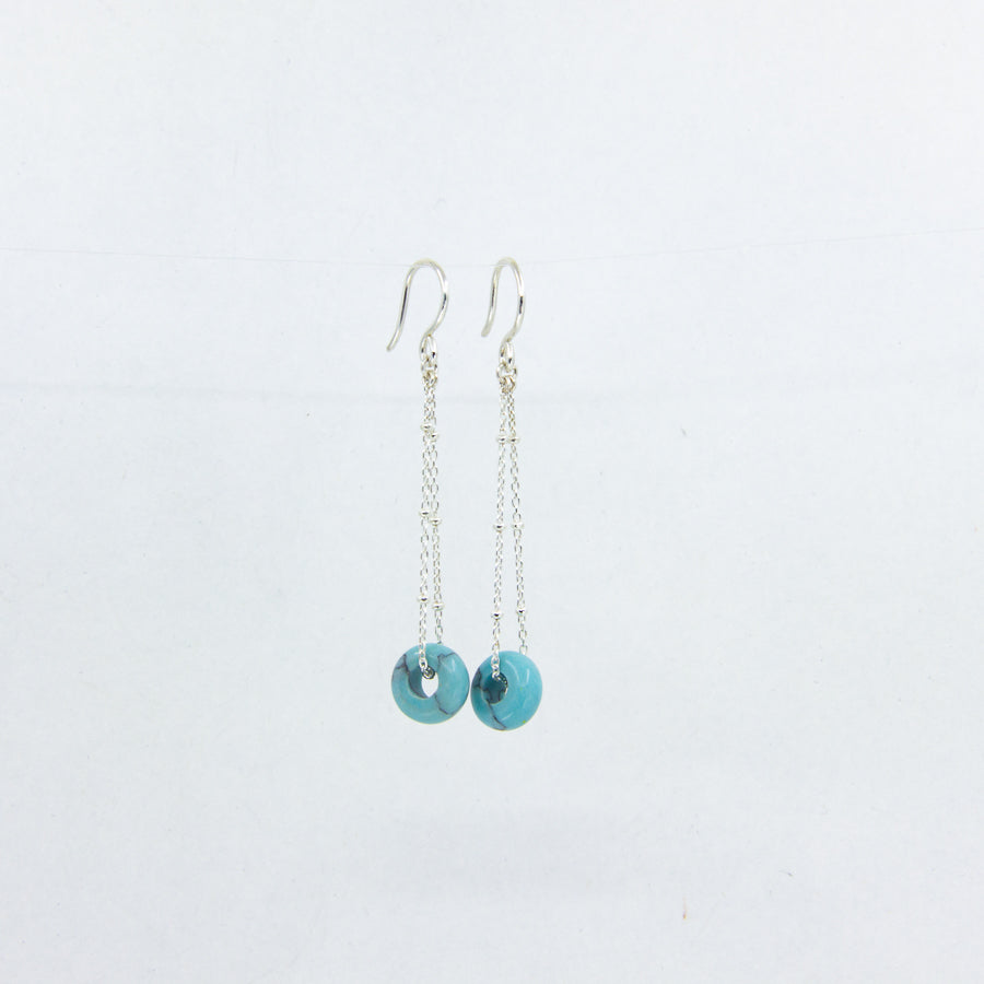 Silver dangle earrings with turquoise gemstones on a white background