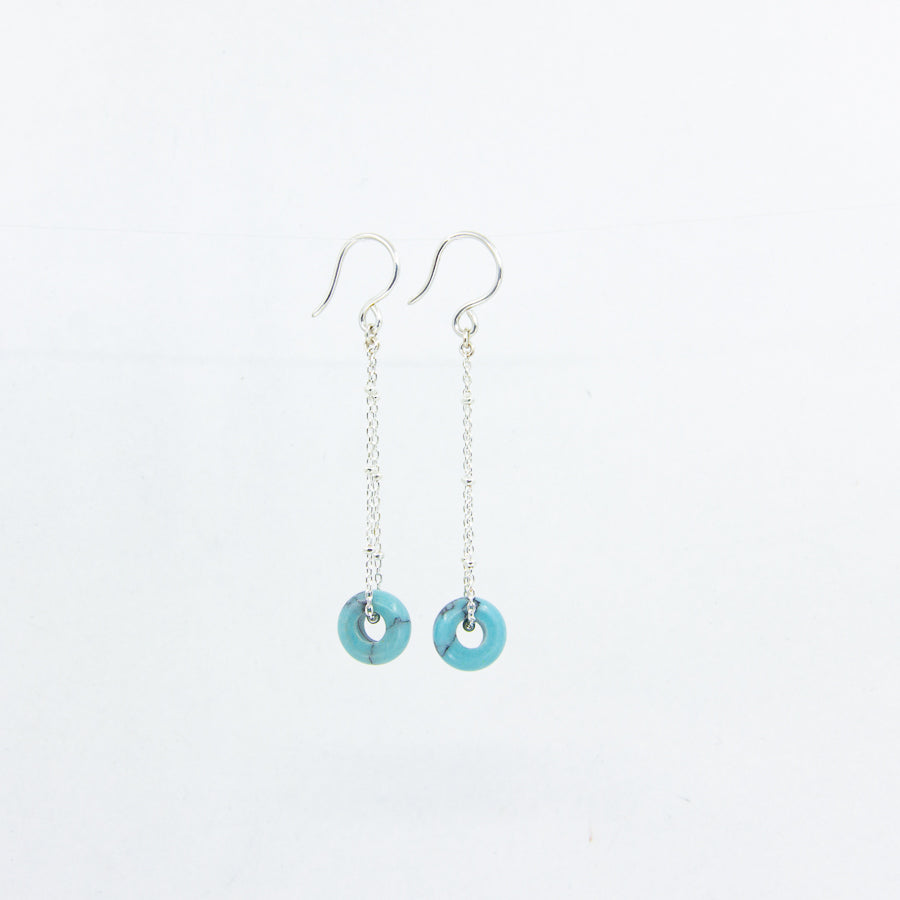 Dangly turquoise gemstone earrings on siver satellite chain, side view on white background