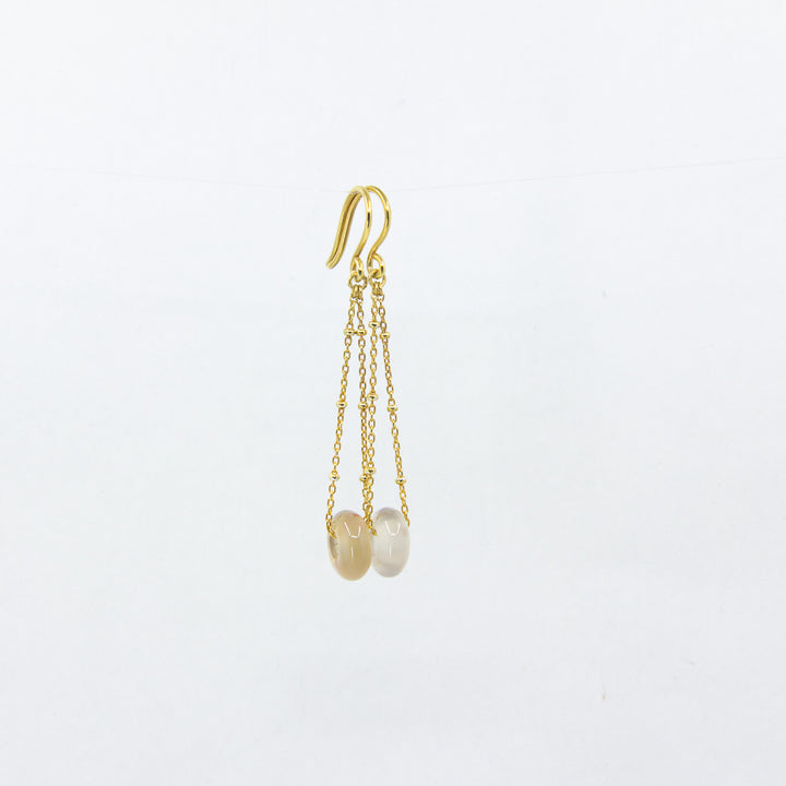 White agate gemstones earrings on gold-plated satellite chain, against a white background