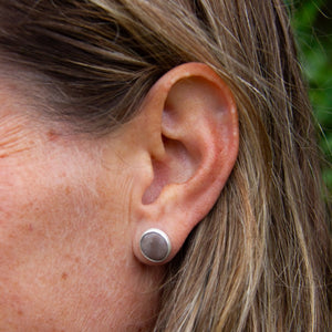 Beach pebble earring set in brushed sterling silver, in left ear of model, part of Found by You Collection