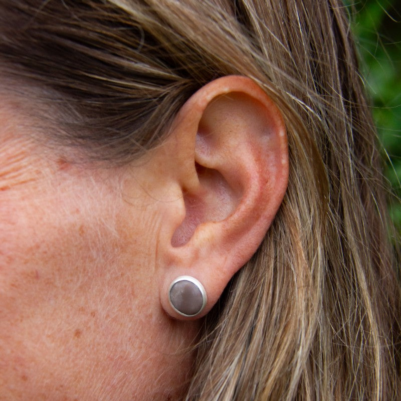 Beach pebble earring set in brushed sterling silver, in left ear of model, part of Found by You Collection