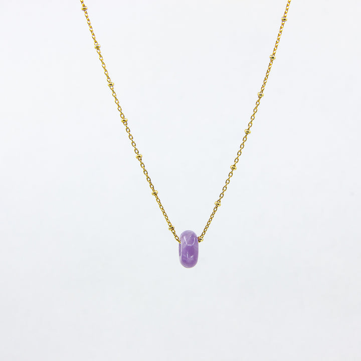 Gold-plated necklace with amethyst gemstone pendant on white background