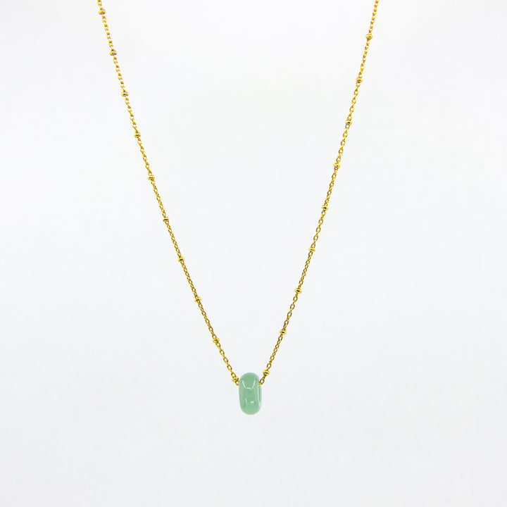 Gold-plated necklace with green aventurine gemstone pendant on white background