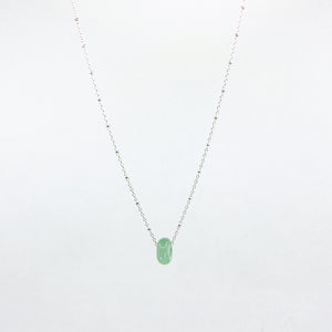 Green gemstone and silver chain necklace on white background