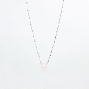 Pink gemstone and sterling silver necklace on white background