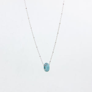Handmade gemstone necklace with turquoise and silver satellite chain, on a white background
