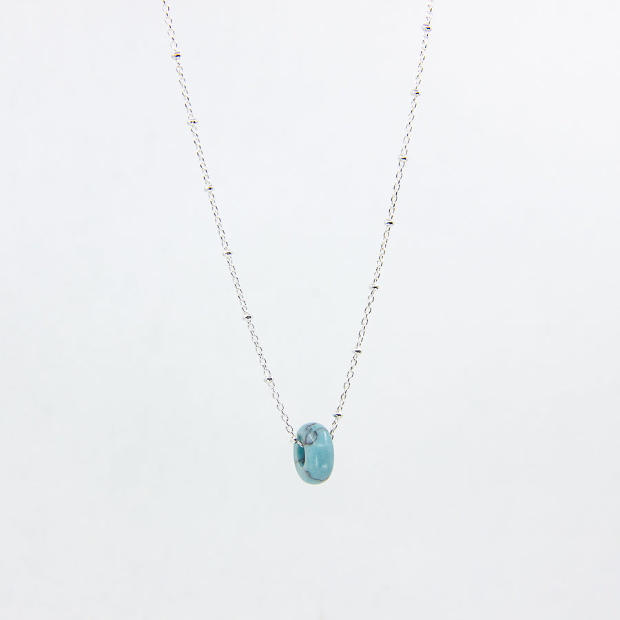 Handmade gemstone necklace with turquoise and silver satellite chain, on a white background
