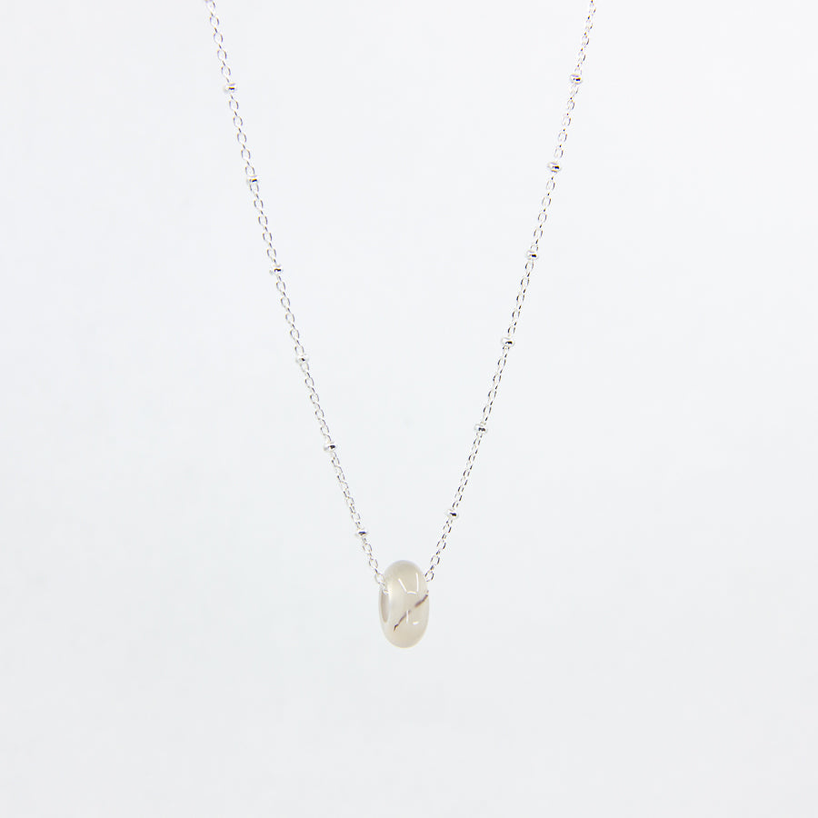 White agate gemstone and sterling silver necklace on white background