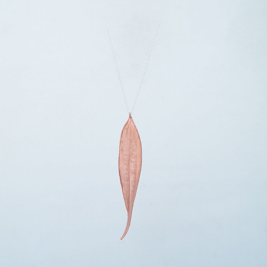 Copper bay leaf on silver chain, zoomed out to show how it hangs
