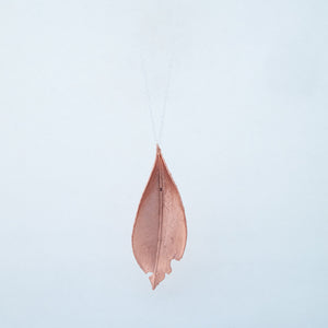 Front of copper laurel leaf on white background, dangling from silver chain