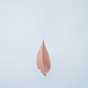 Back of copper laurel leaf on silver chain with white background