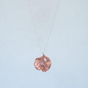 Front view of copper leaf necklace with little hole, plain white background