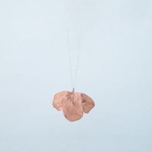 Back view of copper leaf necklace, beautifully lit in white lightbox