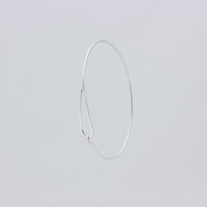 Unusual handmade silver bangle, front view with hook looping into space at bottom of kite-shaped cut out