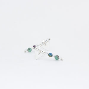 Close up of Eolian earrings, one in front of the other, handmade in sterling silver and emerald and kyanite beads