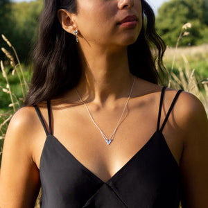 Eolian earring worn with Zephyr necklace, beautiful handmade silver jewellery from the Windblown Collection, long grass behind