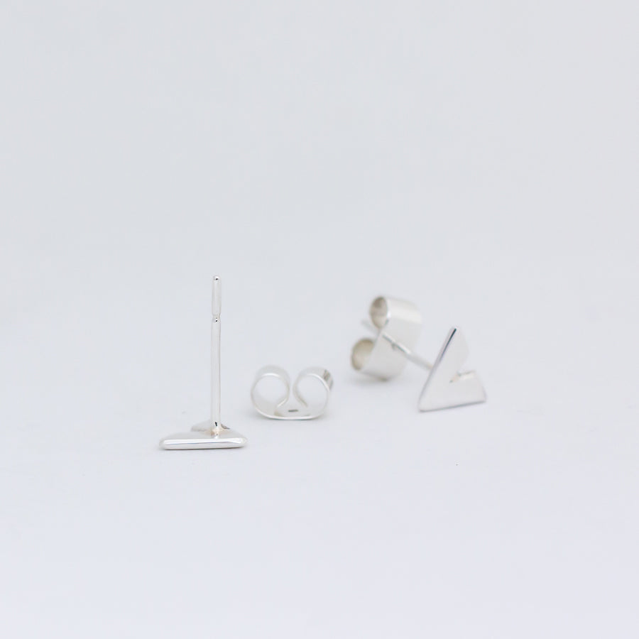 Ear posts of Slipstream stud, with butterfly back behind and earring with back attached