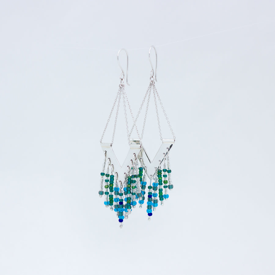 Close up of Windhcharm earrings, displayed close to each other with an overlap on white background