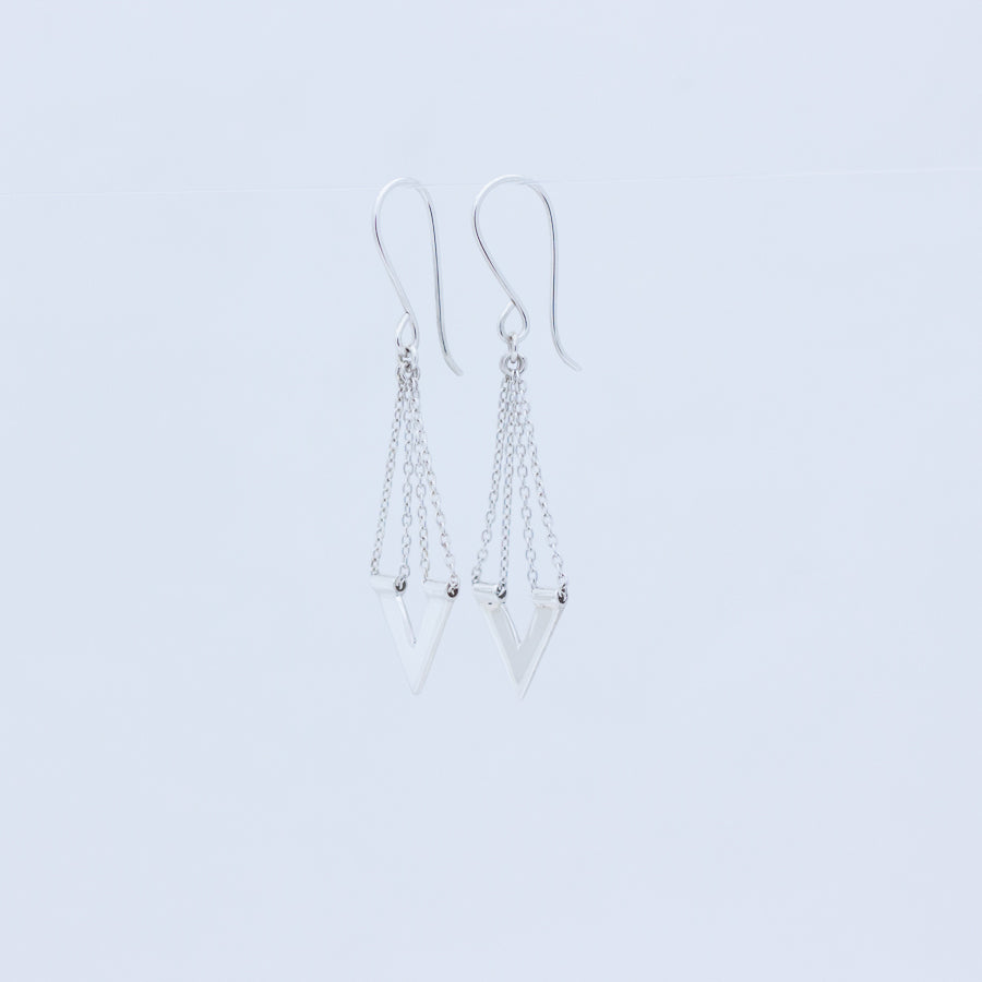 Zephyr earrings sideways view showing chain threaded through tiny tube on top of the V, on white background