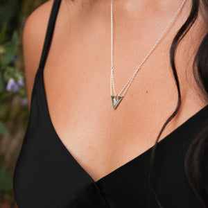 Close up of Zephyr necklace on model's olive skin with dark hair waving slightly to the side