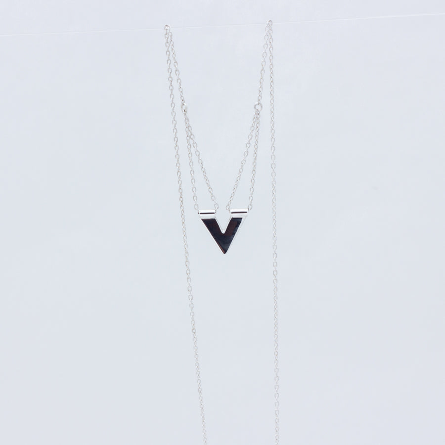 Close up of the handmade Zephyr silver necklace, showing chain loops where the pendant joins to the chain draped on either side